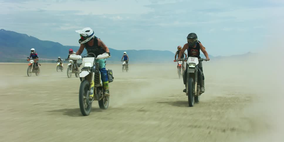 People race motorcycles across soiled terrain
