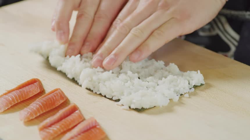 A person is preparing sushi in the kitchen