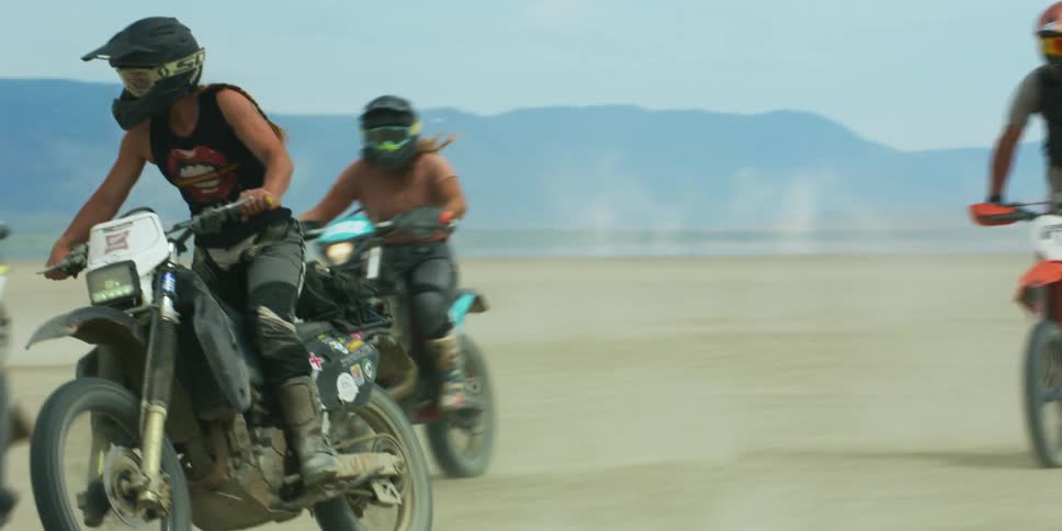 A group of people that are riding motorcycles outdoors