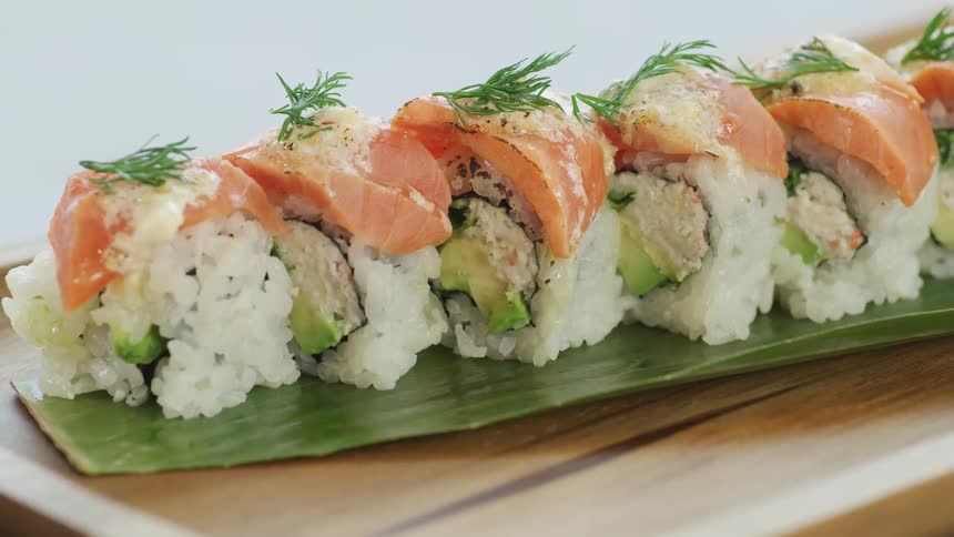 Sushi lined up on a wood board