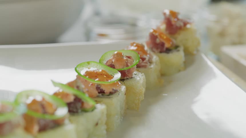 Garnish being put on sushi as it is plated in a restaurant