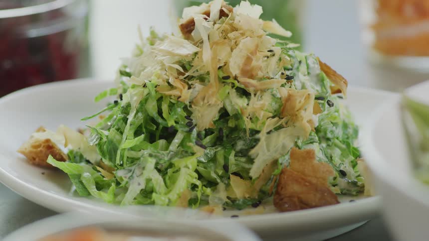 White dishes and glass containers hold vegetables and salad