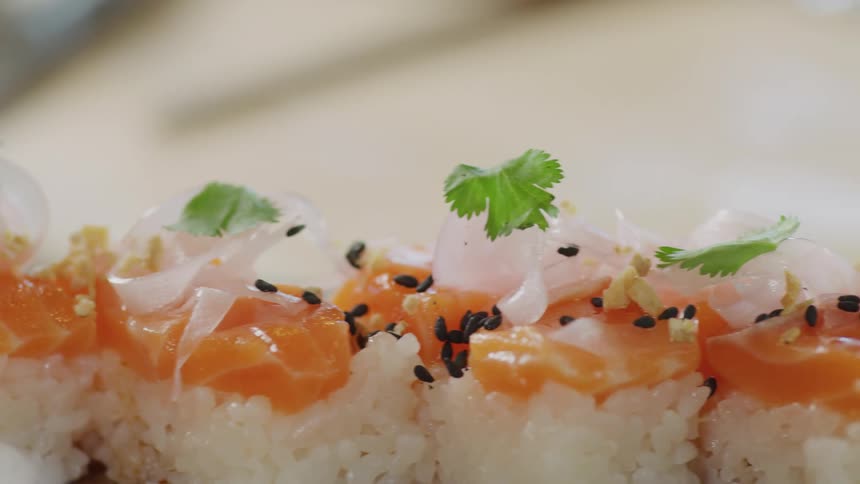 A dish of salmon sushi with black sesame seeds