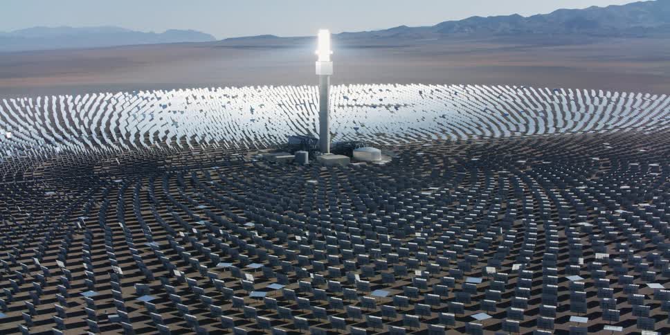 An aerial view of solar panels arranged in a desert in the daytime
