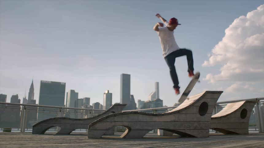 A man does a jump on a skateboard with a city behind him