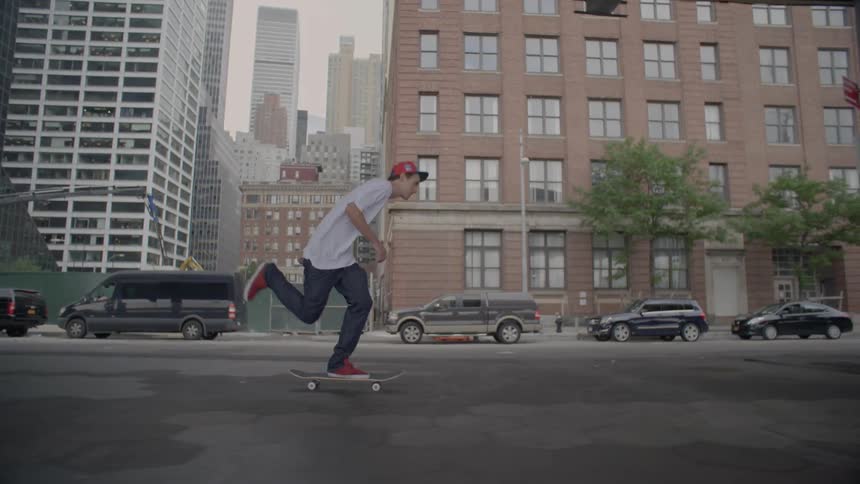 A man rides a skateboard down a city street