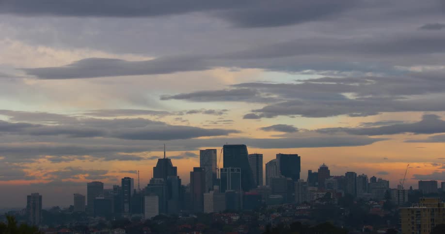 Clouds pass over skyscrapers in a metropolis at sunrise