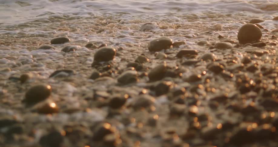 A close up of a rocks on a beat at twilight