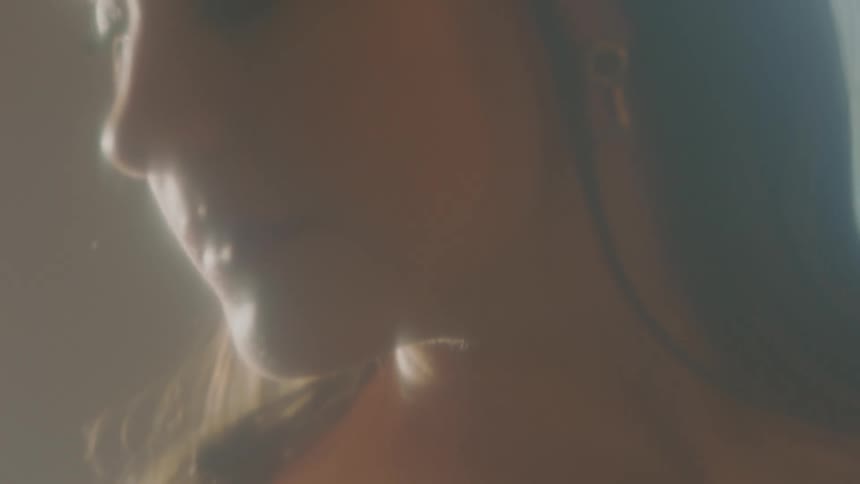 A woman in a room with a wall in the background