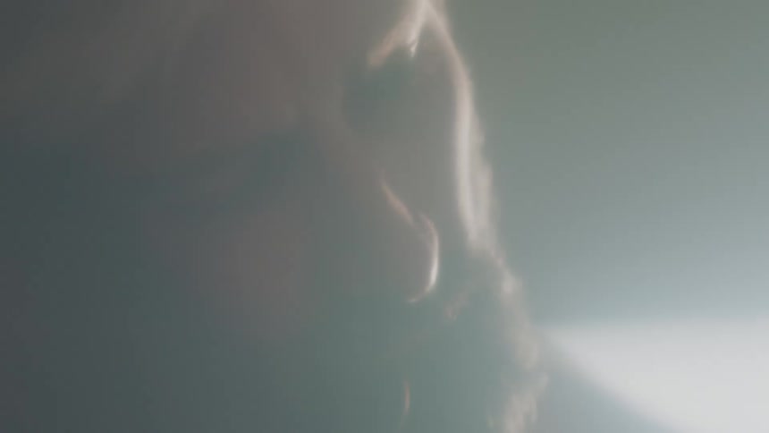 A man in a room with a wall in the background