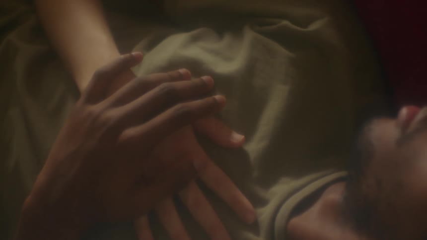 A man covering a womans hand on his chest with his own