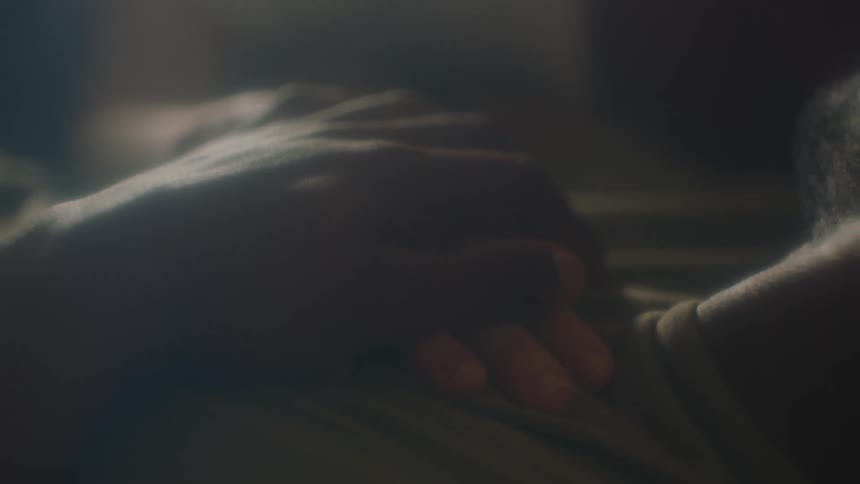 A man and a woman in a room laying in a bed