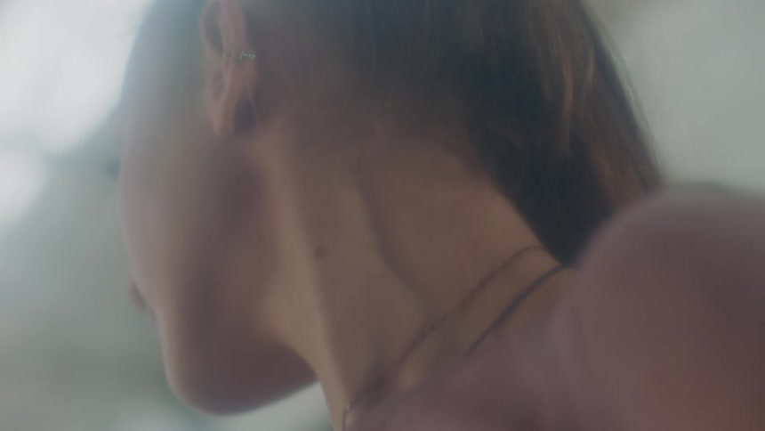 A woman in a room with a wall in the background