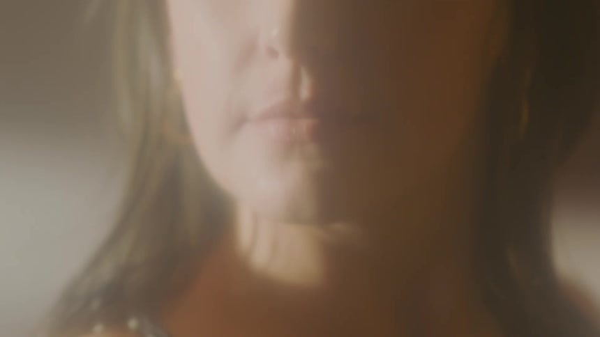 Sunlight creates a haze over a woman as she stands in a room