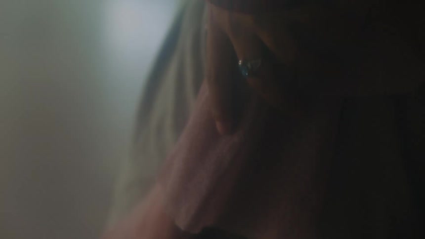 A person touching a piece of clothing with a hand with a ring