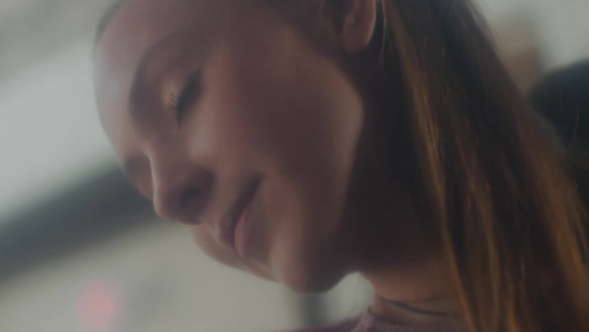 A woman in a room with a wall in the background