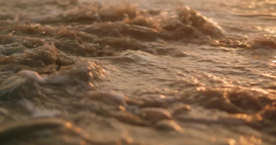 Ocean waves wash over large rocks just under the waters surface