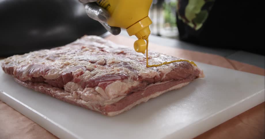 Person putting mustard on food