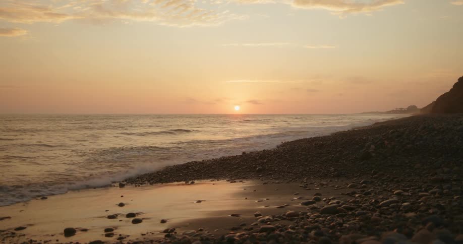 Wide shot of a coastal beach at twilight