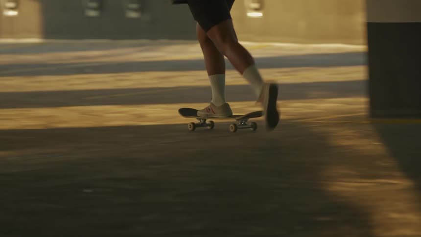 A person riding a skateboard with a wall and a fence in the background