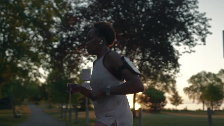 Young woman jogging on a park at sunset