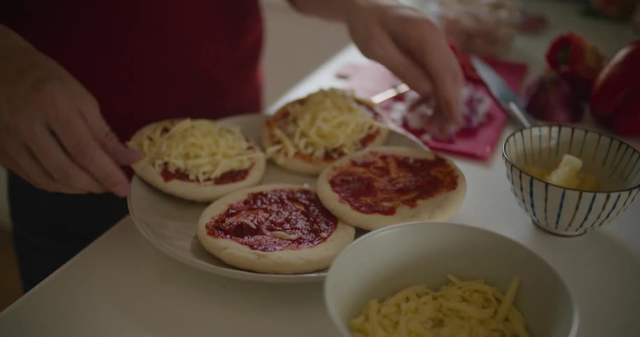 A person is making mini pizzas at home