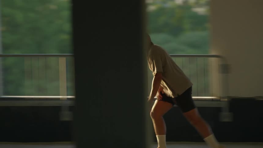 A man is riding his skateboard down the hall