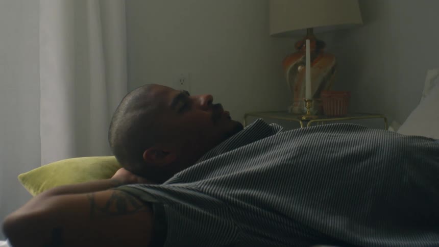 A man is resting on a pillow in his bed