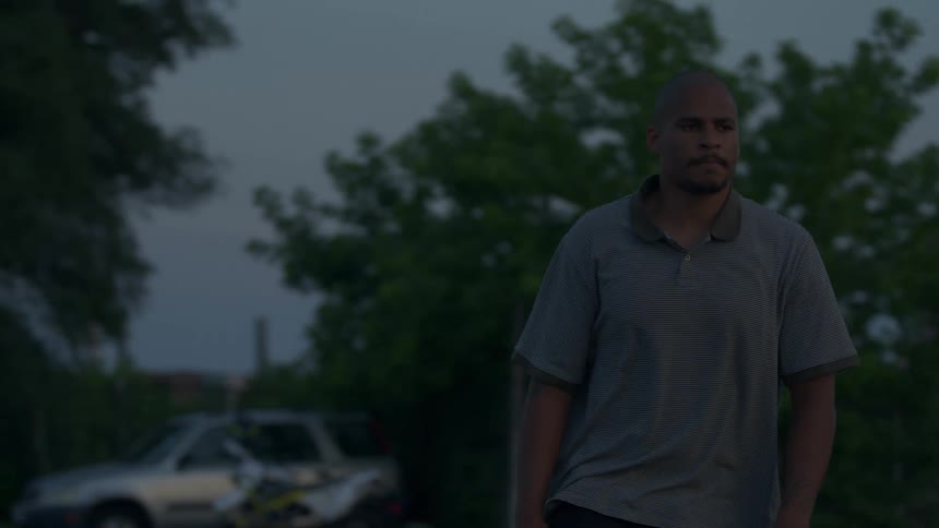 A man roller skates through the parking lot of a business