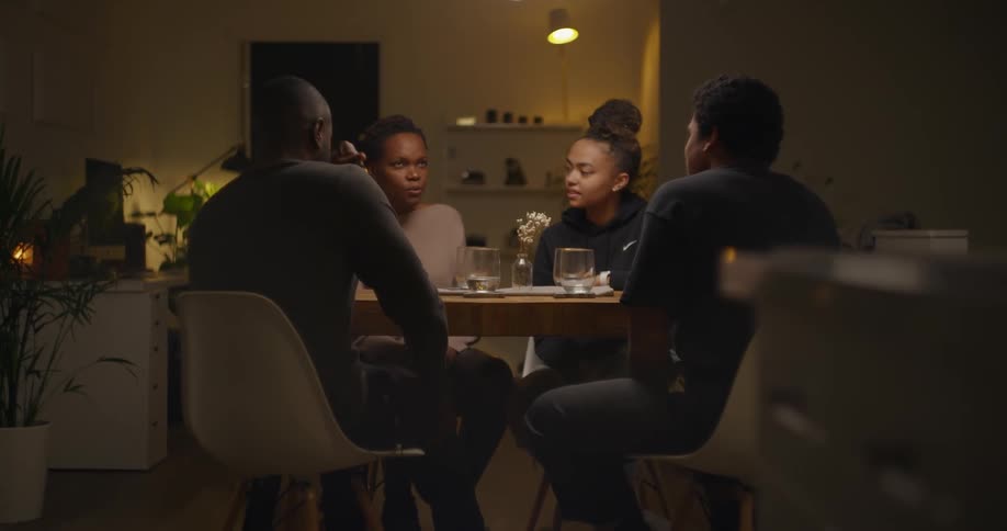 A family chats while sitting down for dinner