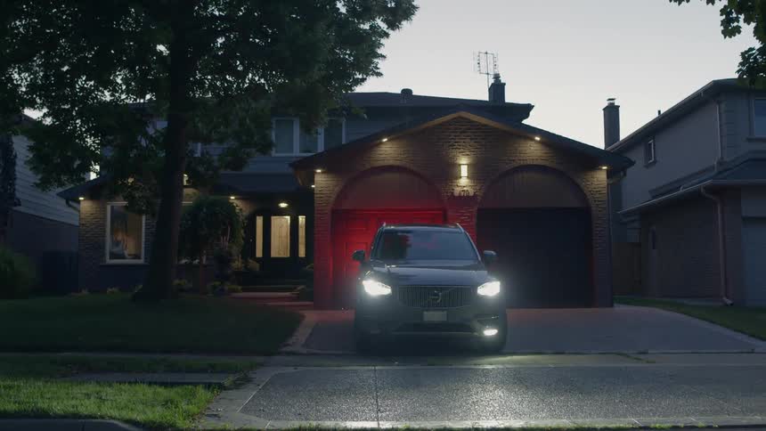 A vehicle parked in a driveway at a home pulls out of the driveway and turns on to the street