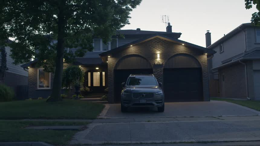 A woman gets into her car after leaving the house