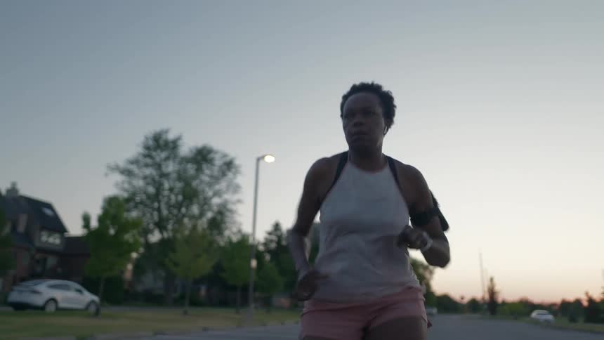A woman running down a road in the day