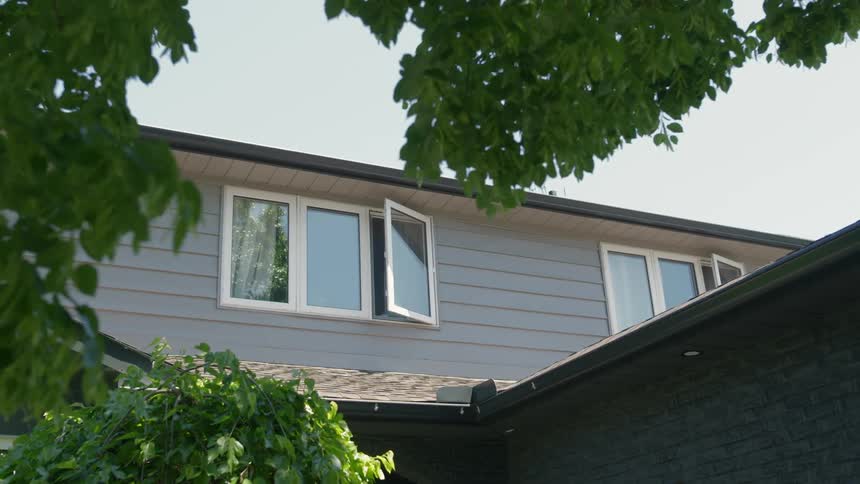 A view of some windows that are open on a house