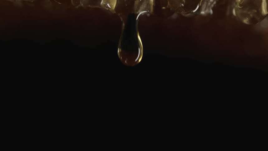 A drop of a brown liquid falling