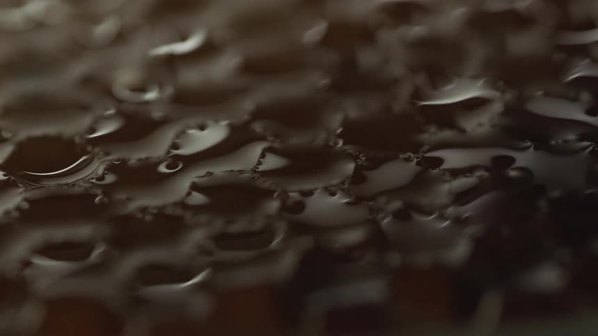 A close view of a honeycomb like material with moisture fading in in a shadowy environment