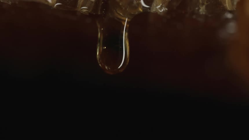 Close up footage of a droplet of honey dripping
