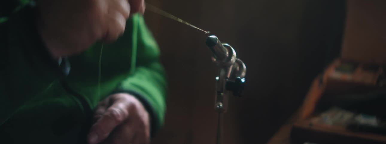 A man winding a string around a screw