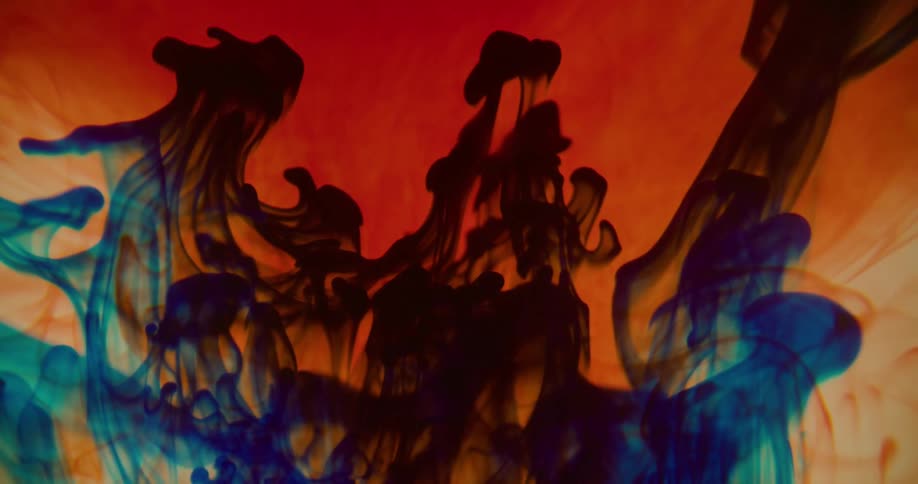 A bright orange liquid has a bluish liquid mixed into it and forming a suspension