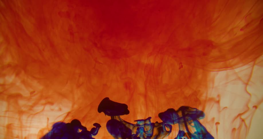 Orange dye and blue dye expand and combine in a clear liquid