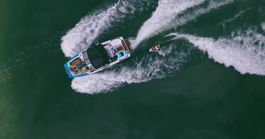 A boat with a man pulled on a board behind it