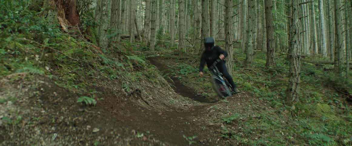 Person riding a mountain bike through tight trail corners