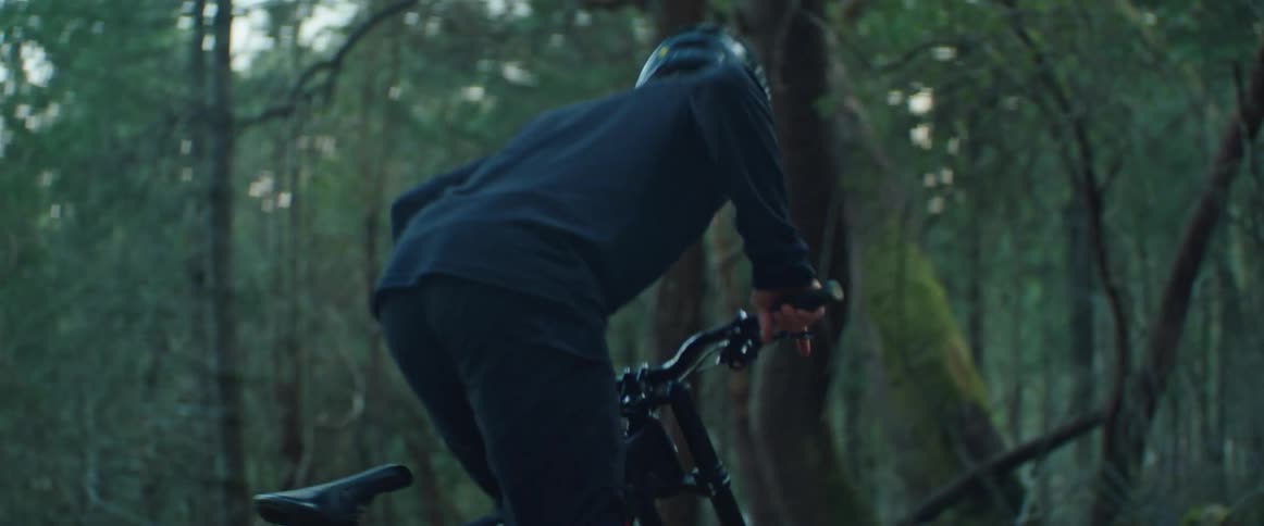 A man drops into a mountain bike trail in the forest