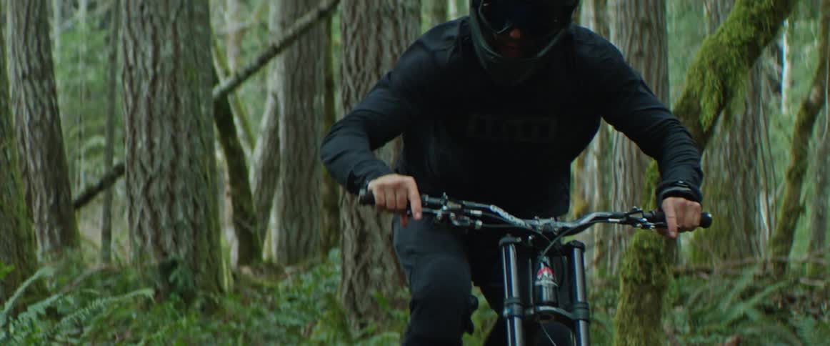 A mountain biker transfers their weight through high-speed trail corners