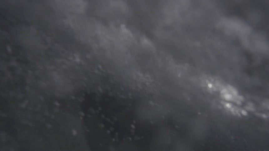 Waves crash and cause bubbles in the water