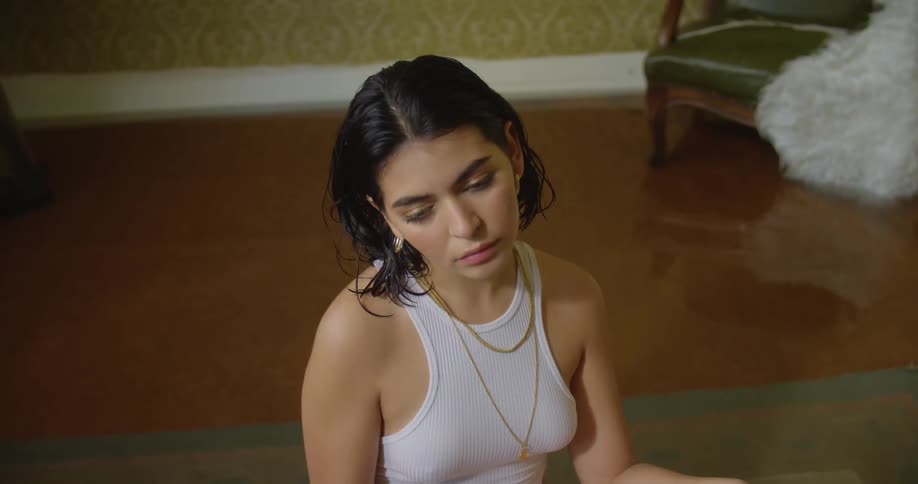A woman looks sad as she sits on the floor in a room