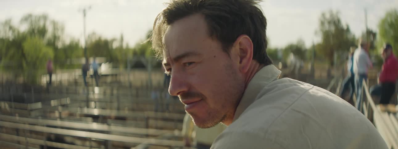 A man is smiling as he looking to his side