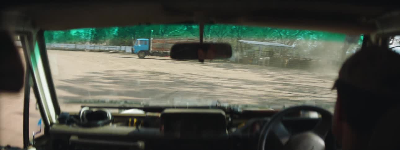A person driving a vehicle with a rearview mirror