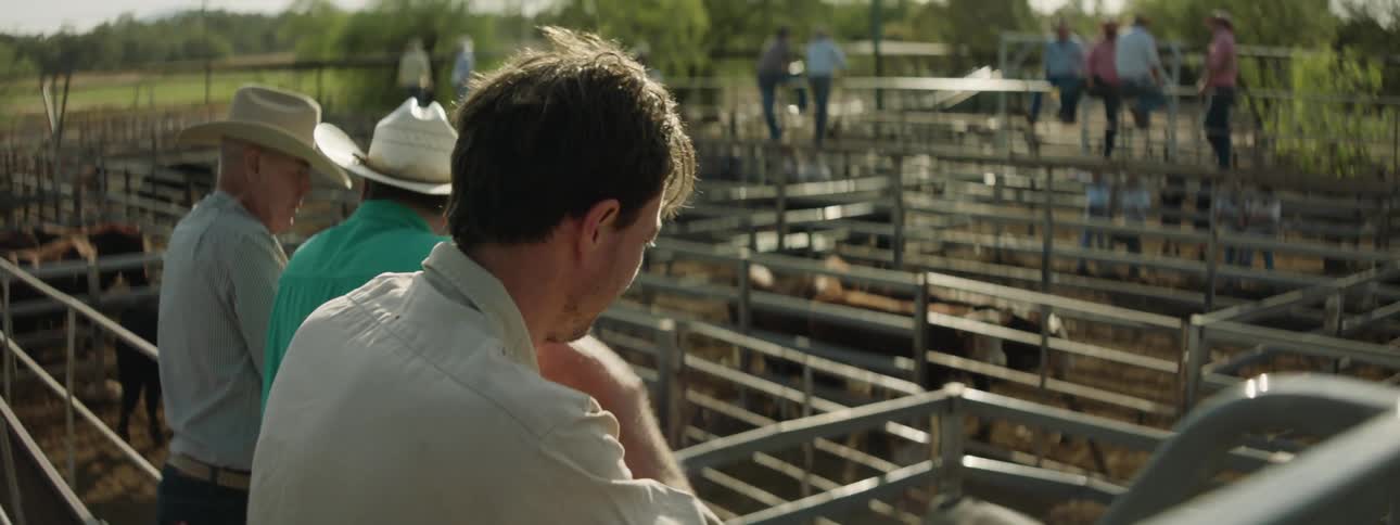 A group of people standing around a farm