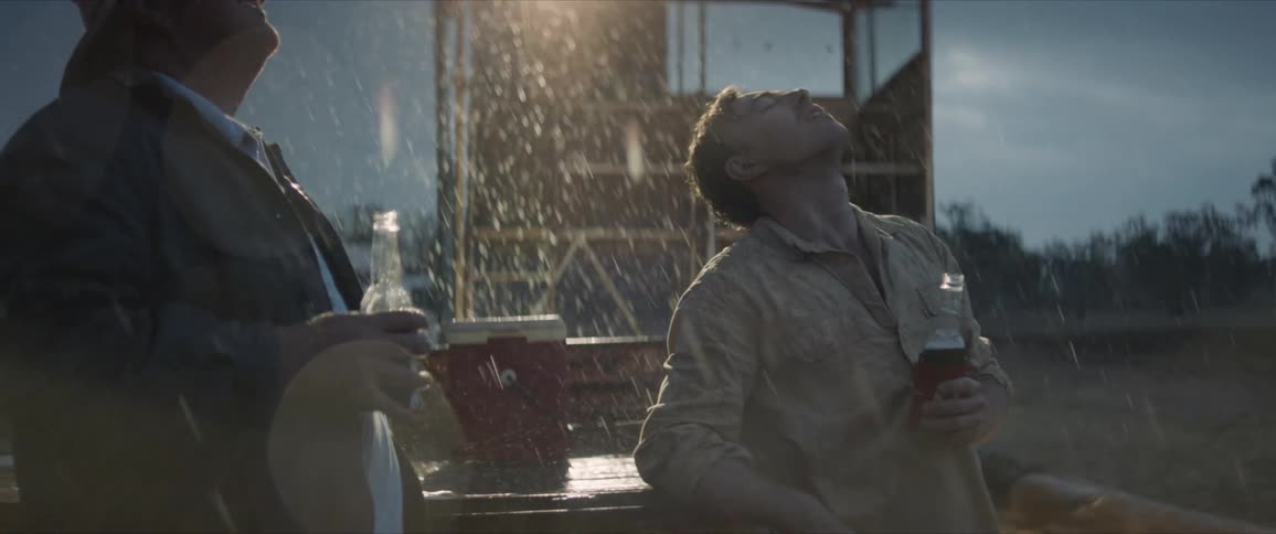 A farmer drinking beer after the rain ends a drought